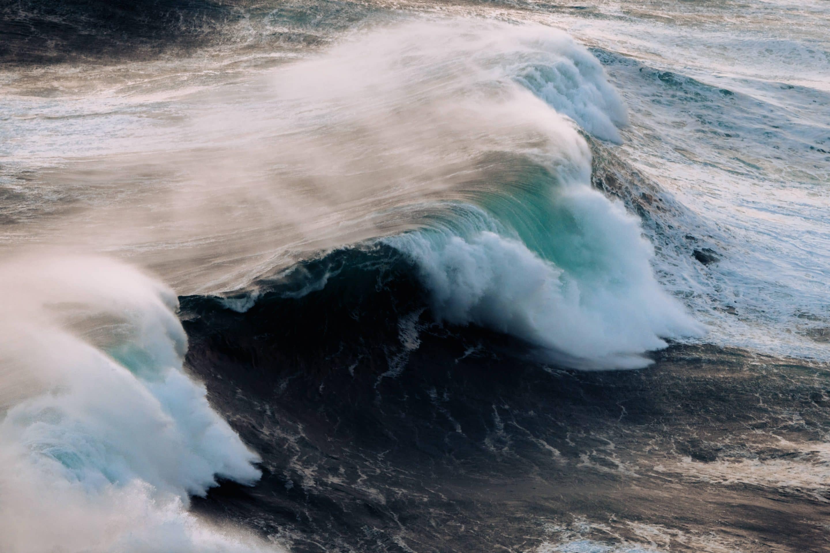 Waves crashing on the Atlantic coast at Nazaré, Portugal during a beautiful sunset by photographer Michael Schauer