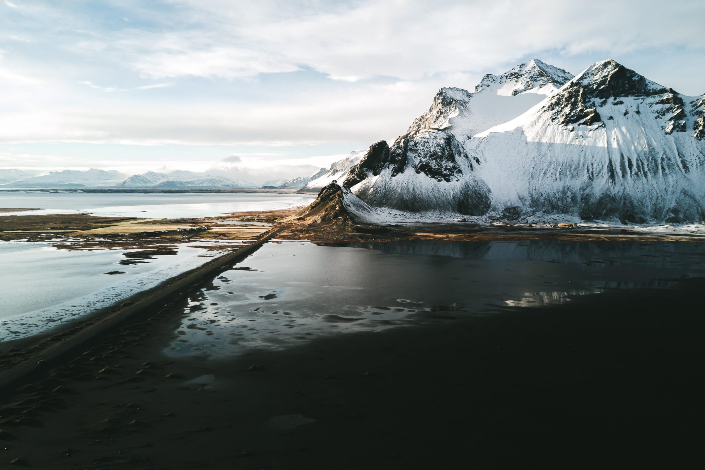 The Stokksnes peninsula in Iceland during a sunset dipping the mountain and beach landscape in moody light by photographer Michael Schauer