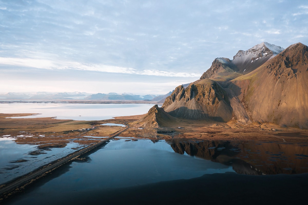 Aerial landscape photography image of the mountains and black sand beach at Stokksnes, Iceland during sunset by Photographer Michael Schauer